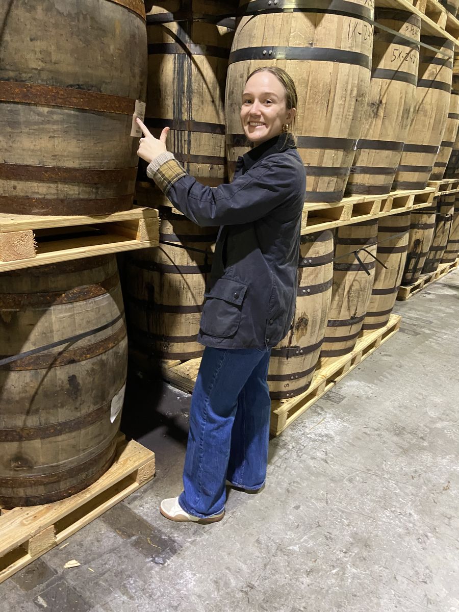 Visitor inspecting bourbon barrels