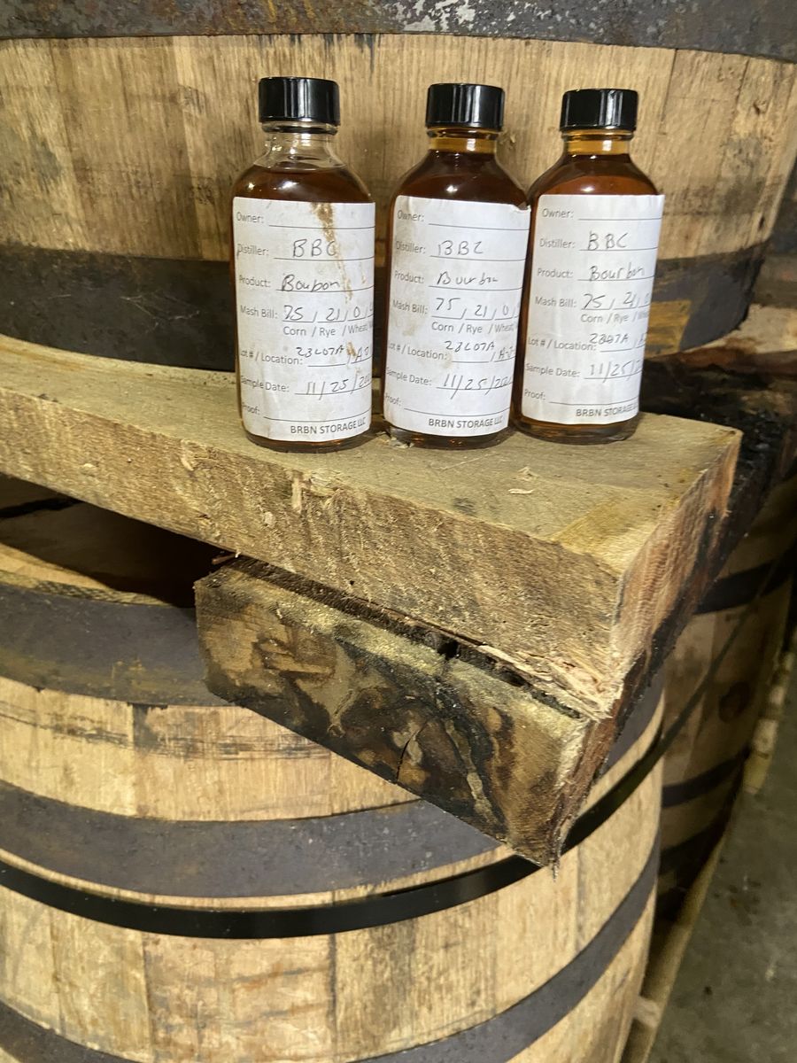 Bourbon sample bottles resting on barrel staves